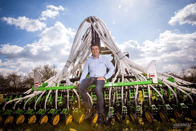 Photo du Directeur d'Aurensan devant une machine agricole